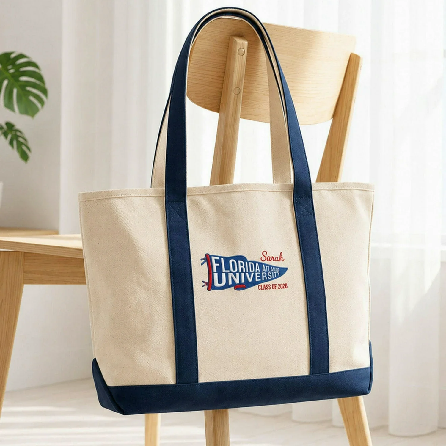 Canvas tote bag printed with a university pennant graphic, a personalized first name and a class year