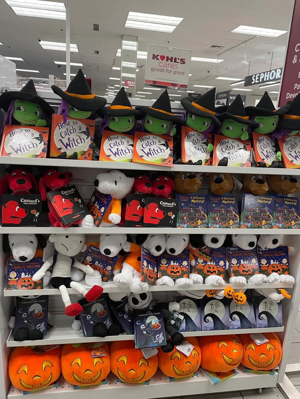 Retail shelf stocked with licensed Halloween character plush toys and picture books