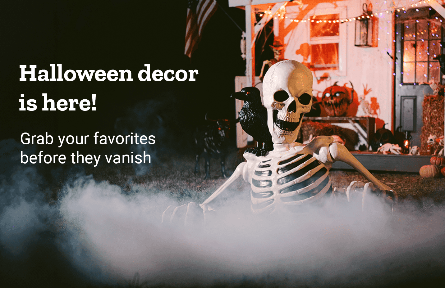 Skeleton figure sitting in fog outside a house decorated with lights, pumpkins and a black crow, under the words Halloween decor is here