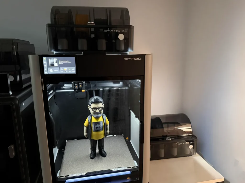 Small printed figurine on the build plate inside a desktop 3D printer